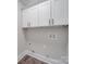 Bright laundry room features white cabinets, wood floor, and modern utility connections at 1304 Pleasant Plains Rd, Matthews, NC 28105