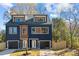 Modern two-unit building, navy and brown, with attached garages and fenced yards at 137 S Smallwood Pl, Charlotte, NC 28208