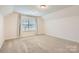 Spacious bedroom with carpeted floor and large window at 137 Yellow Birch Loop, Mooresville, NC 28117