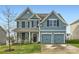 Two-story house with blue siding, two-car garage, and landscaping at 137 Yellow Birch Loop, Mooresville, NC 28117