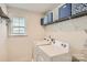 Bright laundry room, featuring washer, dryer, and shelving for storage at 137 Yellow Birch Loop, Mooresville, NC 28117