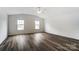 A large bedroom featuring two windows, neutral paint and wood-look flooring at 3028 Semmes Ln, Indian Trail, NC 28079