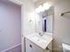 White bathroom vanity with sink and mirror at 4830 Carnbrook Pl, Charlotte, NC 28212