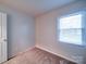 Simple bedroom with window, carpet, and neutral-colored walls at 4830 Carnbrook Pl, Charlotte, NC 28212