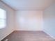 Cozy bedroom with a window, neutral wall, and carpet flooring at 4830 Carnbrook Pl, Charlotte, NC 28212