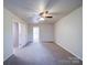 Carpeted bedroom with ceiling fan and access to another room at 4830 Carnbrook Pl, Charlotte, NC 28212