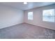 Bright bedroom with neutral walls, carpet flooring, and two windows at 4830 Carnbrook Pl, Charlotte, NC 28212