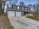 Two-story house with gray siding, white garage doors, and a covered porch at 4830 Carnbrook Pl, Charlotte, NC 28212