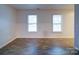 Living room with hardwood floors and two large windows at 4830 Carnbrook Pl, Charlotte, NC 28212