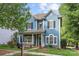 Beautiful two-story blue house with a front porch and well-manicured lawn at 9243 Island Overlook Ct, Cornelius, NC 28031