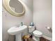 Chic powder room with pedestal sink, toilet, and decorative mirror at 9243 Island Overlook Ct, Cornelius, NC 28031