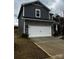 A two-story home with gray siding and stone accents, featuring an attached two-car garage and concrete driveway at 102 Alden Ct, Shelby, NC 28152
