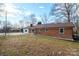 Exterior of brick home with grassy backyard featuring a small chain link fence at 1254 Huckleberry Dr, Lincolnton, NC 28092