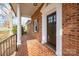 Charming front porch with brick, stately columns, and black paneled door at 1254 Huckleberry Dr, Lincolnton, NC 28092