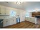 Well-lit kitchen with stainless steel appliances, white cabinets, countertops, and hardwood floors at 1254 Huckleberry Dr, Lincolnton, NC 28092