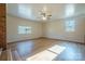 Spacious living room features neutral paint, ceiling fan, and two windows providing natural light at 1254 Huckleberry Dr, Lincolnton, NC 28092