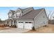 Gray two-story house with white garage doors and landscaping at 13026 Arnold Palmer Cir # 1051, Lancaster, SC 29720