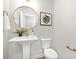 Elegant powder room with pedestal sink, decorative mirror, and gold accents at 13026 Arnold Palmer Cir # 1051, Lancaster, SC 29720