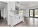 White kitchen with island, stainless steel appliances, and dark hardwood floors at 5442 Kinsale Ln, Charlotte, NC 28215