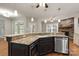 Island kitchen with granite countertops, stainless steel appliances, and stone fireplace at 1076 Fox Chase Dr, Newton, NC 28658