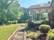 Lush backyard with stone pathway leading to a covered porch and wooded area at 16480 Indian Mound Rd, Norwood, NC 28128