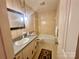 Bathroom with tub, vanity, and patterned wallpaper at 16480 Indian Mound Rd, Norwood, NC 28128