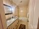 Vintage bathroom featuring wallpaper, a vanity sink, and a combined tub and shower at 16480 Indian Mound Rd, Norwood, NC 28128