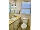 Vintage-style bathroom with unique patterned wallpaper, decorative light fixture, and window at 16480 Indian Mound Rd, Norwood, NC 28128