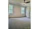 Spacious carpeted bedroom featuring dual windows and a modern ceiling fan at 16480 Indian Mound Rd, Norwood, NC 28128