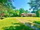 Traditional brick home featuring a well-manicured lawn and mature trees at 16480 Indian Mound Rd, Norwood, NC 28128