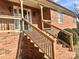 Brick steps leading to the front door with a wooden railing at 16480 Indian Mound Rd, Norwood, NC 28128