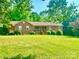 Charming brick home featuring a covered porch and a well-manicured lawn at 16480 Indian Mound Rd, Norwood, NC 28128