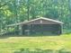 Outbuilding surrounded by lush green grass and tall trees at 16480 Indian Mound Rd, Norwood, NC 28128