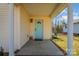 Covered porch with a light teal door and brick flooring at 222 E Alabama Ave, Bessemer City, NC 28016