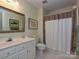 Bathroom with shower/tub combo, white vanity and plaid shower curtain at 232 Perrin Pl, Charlotte, NC 28207