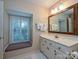 Bathroom with window seat, white vanity and a large mirror at 232 Perrin Pl, Charlotte, NC 28207