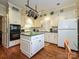 Bright kitchen with white cabinets, island, and hardwood floors at 232 Perrin Pl, Charlotte, NC 28207