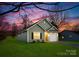 One-story house with a green exterior, white garage door, and a landscaped yard at 5513 Skycrest Dr, Charlotte, NC 28269