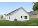 Rear view of a single-story house with white siding and small patio at 5513 Skycrest Dr, Charlotte, NC 28269