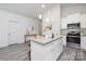 Modern kitchen with white cabinets, granite island, and stainless steel appliances at 5513 Skycrest Dr, Charlotte, NC 28269