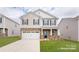 Charming two-story home featuring stone accents, a two-car garage, and a well-manicured lawn at 126 Rustling Waters Dr, Mooresville, NC 28117