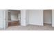 An open-concept bedroom features neutral carpet, white walls, and an entrance to a room with wood floors at 320 Triple Ponds Ct, Clover, SC 29710