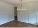 Open-concept dining room with hardwood floors, elegant chandelier, and paneled walls at 320 Triple Ponds Ct, Clover, SC 29710