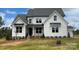 Stunning two-story home featuring a modern farmhouse design with a manicured lawn and welcoming entrance at 320 Triple Ponds Ct, Clover, SC 29710