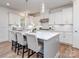 This spacious kitchen features white cabinets, stainless steel appliances, and a large island with bar seating at 320 Triple Ponds Ct, Clover, SC 29710