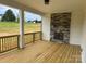 Inviting covered patio with a stone fireplace and wood flooring, perfect for outdoor relaxation and entertainment at 320 Triple Ponds Ct, Clover, SC 29710