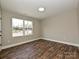 This bedroom features wood-look floors, and a large window overlooking the street at 409 Mint St, Rock Hill, SC 29730