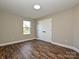 This is a bedroom with wood-look floors, a double closet, and a large window at 409 Mint St, Rock Hill, SC 29730