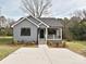 Charming gray home featuring a well-manicured lawn, black trim windows, and concrete driveway at 409 Mint St, Rock Hill, SC 29730