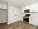 Cozy kitchen featuring stainless steel appliances, white cabinetry, and hardwood floors at 409 Mint St, Rock Hill, SC 29730